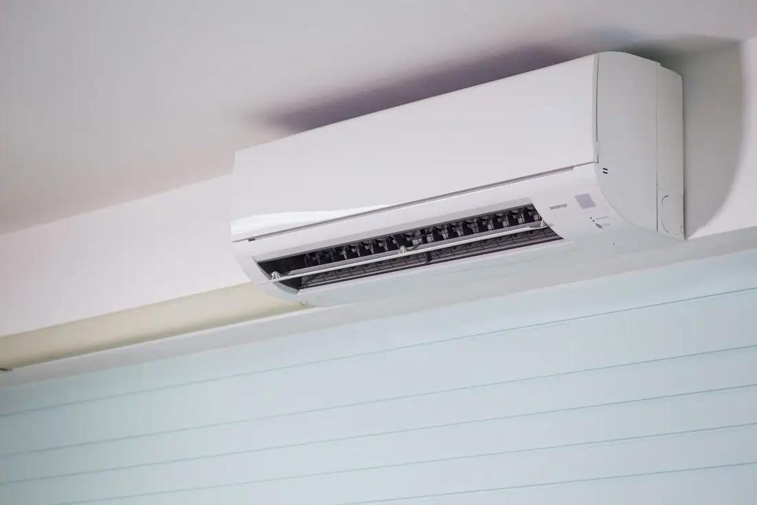 A white ductless mini split indoor head mounted high on a wall